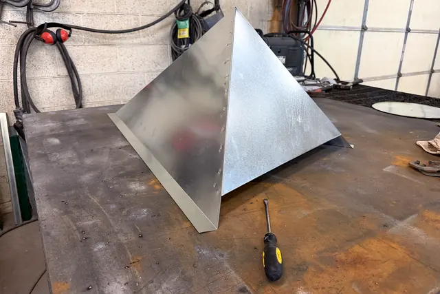 A custom galvanized piece, formed and riveted, on the fabrication bench in the Macias shop.