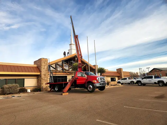 The Macias crane truck working at a church, with crew on the roof.