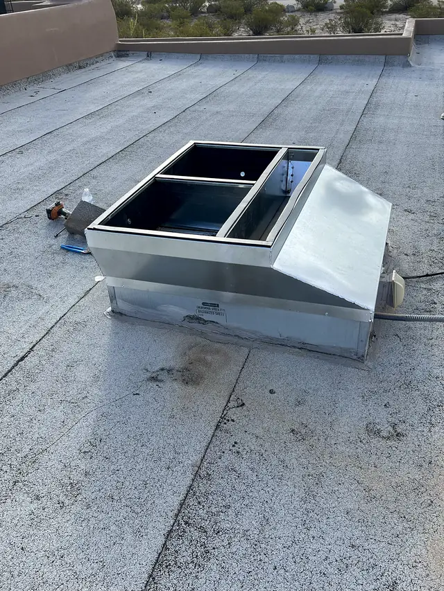 The same galvanized curb adapter set on a flat commercial roof.