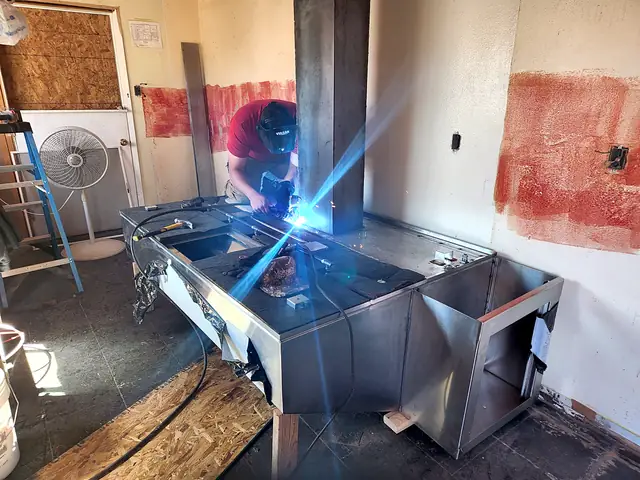 A Macias welder at work on stainless commercial hood work, sparks flying.
