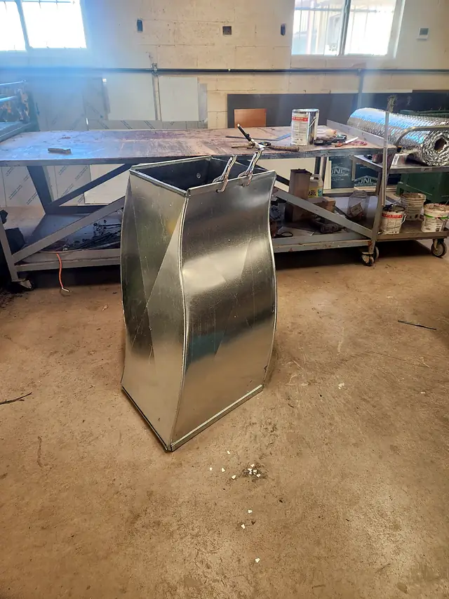 A tall galvanized offset transition standing on the shop floor.