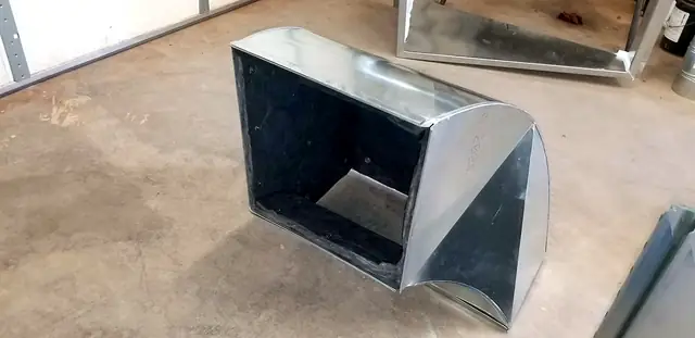 A rectangular galvanized radius elbow on the shop floor.